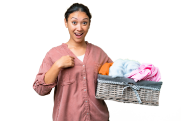 Young Uruguayan woman holding a clothes basket over isolated chroma key background with surprise facial expression
