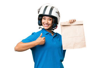 Young Argentinian woman taking a bag of takeaway food over isolated background with thumbs up because something good has happened
