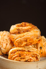 Handmade Spicy Pork Puff Pastry Rolls with Flaky Layers in Wooden Bowl