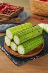 Fresh Green Skinned Shouguang Long Loofah from Shandong China on Wooden Plate