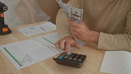 Obraz premium Man hands counting at home desk display young hispanic boxes containing cash near calculator and bills.