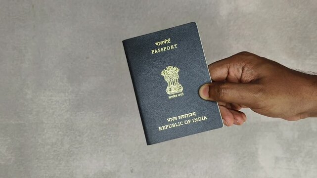 Hand holding Indian nationality or citizenship official identification document general passport isolated on white background with copy space. International tour and travel identity concept.