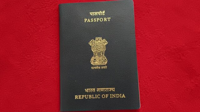 Old Indian nationality or citizenship official identification document ordinary passport with embossed gold text isolated on table background. International tour and travel identity concept.