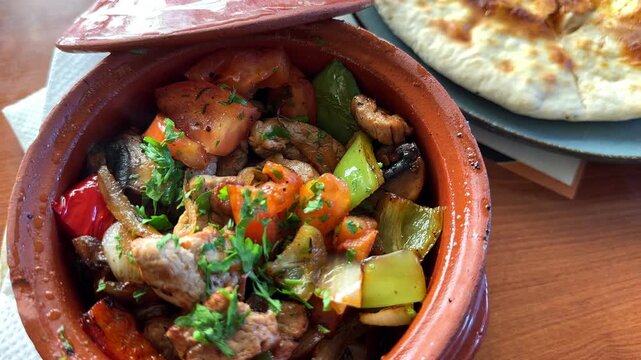 Pork Gyuveche Kavarma in Clay Pot with Peppers, Mushrooms and Tomatoes, Traditional Balkan Bulgarian Serbian Romanian Greek Food Cuisine