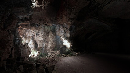 Exploring the depths of a dark cave, revealing stunning rock formations and soft illumination. The interplay of light and shadows creates a mysterious and tranquil atmosphere, inviting adventure.