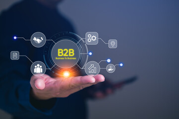 B2B business to business concept, person's hand holding a smartphone and various icons representing business and technology connections, digital marketing