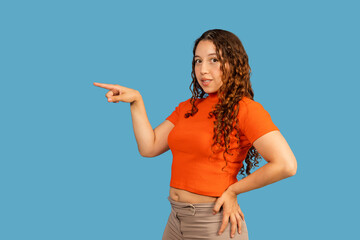 Woman pointing index finger away on blue background