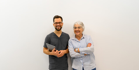 Portrait of smiling male ophthalmologist with senior patient standing together against white background
