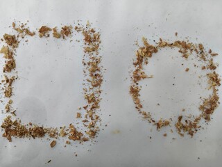 Debris-formed square and circle shapes on white surface in minimal geometric art composition