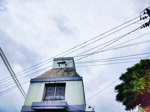 heritage building with unique tapered roofline and tangled cables above