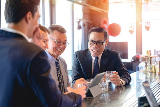Group of business professionals discussing strategy and ideas during a corporate meeting using a digital tablet. Concept of teamwork, leadership, and innovation in a modern office.