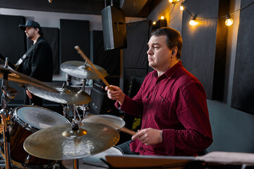 Musicians Rehearsing in a Studio with a Drummer and Bass Player