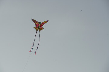 Butterfly shaped kite flying in the sky.