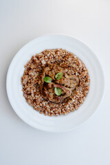 Refined dish featuring sliced roasted meat atop a grain medley buckwheat with crunchy texture and subtle greens for color. Clean, modern presentation suitable for upscale dining and food photography.
