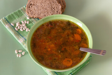 Bean soup with celery, carrots and potatoes close-up