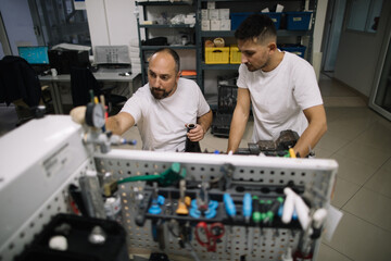 Two technicians working together in workshop