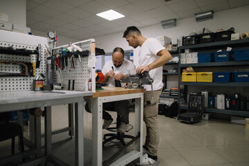 Two technicians collaborating on prosthetic arm in workshop