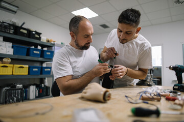 Two orthopedic specialists assembling artificial limb together