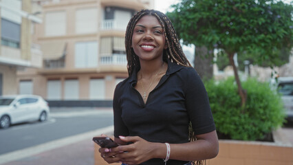 Woman texting on smartphone, hands visible holding device on urban street near parked car and apartment building; focused concentration.