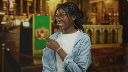 Obraz premium Woman points finger and places finger to lips for silence in church interior near altar and rope barrier; reverence.