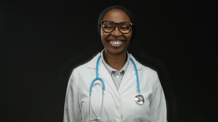 Woman doctor in white coat with stethoscope sending kiss on black background shines in professional...