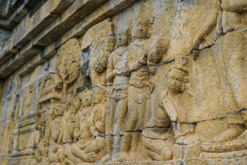 Detailed Buddhist relief art on Borobudur temple walls