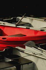 Rowing boat with paddles resting on another grey boat, captured in warm sunlight by the water. © eugenivy