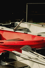 Rowing boat with paddles resting on another grey boat, captured in warm sunlight by the water. © eugenivy