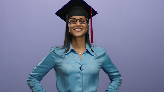 Confident woman in graduation cap over purple background stands smiling, representing academic achievement and cultural pride with elegance and professionalism.