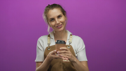 Woman smiling holding coffee cup wearing apron against vibrant purple background suggests warmth hospitality joy informal setting ideal for cafe promotions