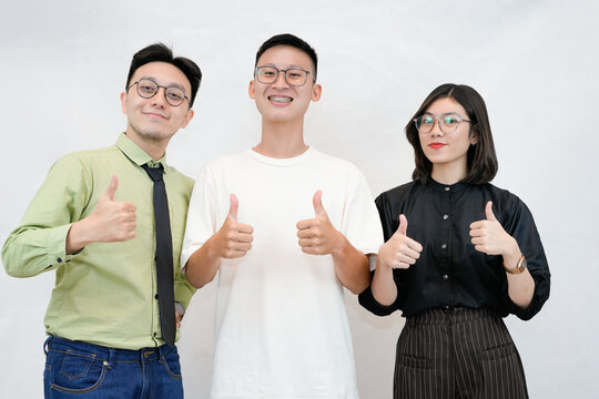 Three friends smiling and giving thumbs up together, positive teamwork and friendship theme