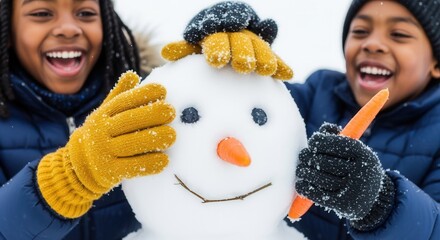 Joyful African American siblings building a snowman in winter. Close-up of a happy boy and girl playing together in the snow and having fun