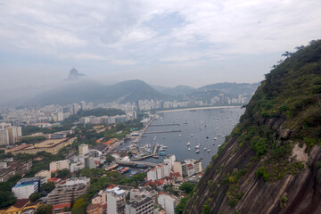 Obraz premium Aerial view from cable car at Urca Hill and Sugarloaf Mountain at Brazilian city of Rio on a cloudy spring day. Photo taken October 12th, 2025, Rio de Janeiro, Brazil.