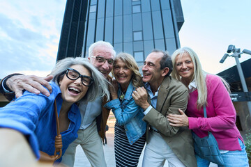 Group of senior friends taking selfie in city