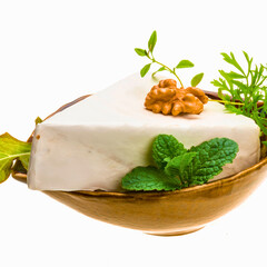 Triangular wedge of creamy cheese topped with walnut and herbs