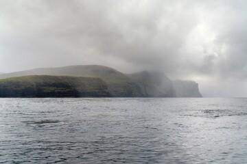 view of the iconic Vestmannabjorgini or Vestmanna Cliffs on Streymoy Island in the Faroe Island Archipelago on a foggy and overcast day