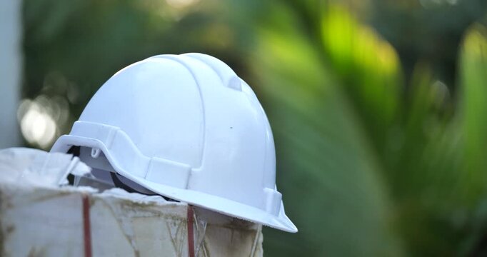 White safety helmet on pile of bricks in construction site with beautiful sunlight,safe construction site