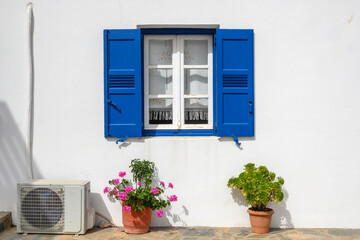 Window with blue shutters of a typical Greek house in Aegiali village on the island of Amorgos. Cyclades, Greece