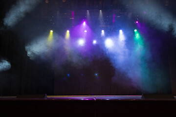 An empty stage of the theater, lit by spotlights and smoke before the performance