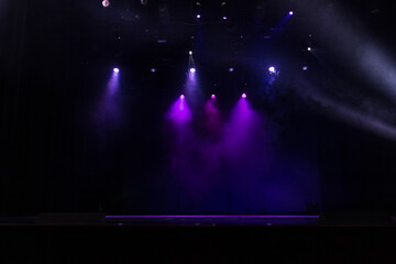Spotlights in the concert hall. Stage light with colored spotlights and smoke.