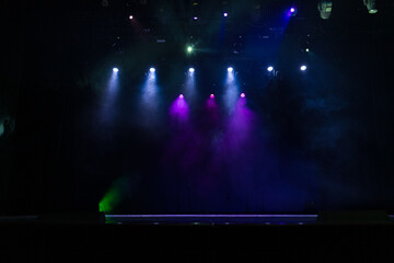 Spotlights in the concert hall. Stage light with colored spotlights and smoke.