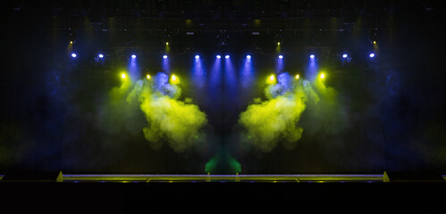 An empty stage of the theater, lit by spotlights and smoke before the performance