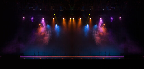 Spotlights in the concert hall. Stage light with colored spotlights and smoke.