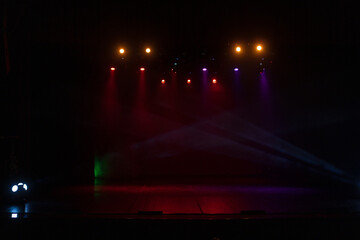 Spotlights in the concert hall. Stage light with colored spotlights and smoke.