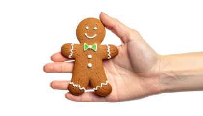 A hand holding a delicious gingerbread man cookie