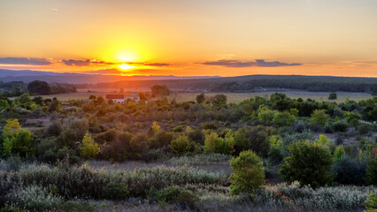 Obraz premium Colorful sunset over rural landscape near Obzor, Bulgaria with warm evening light and tranquil summer mood