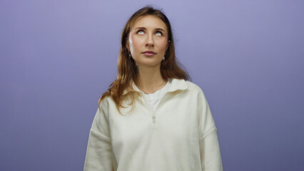 Fototapeta premium Woman expressing emotion over isolated purple background with a thoughtful pose, highlighting casual fashion and youthful energy in a minimalist setting.