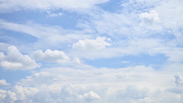Peaceful time-lapse of soft white clouds drifting across light blue sky in daylight, no people, natural weather background.