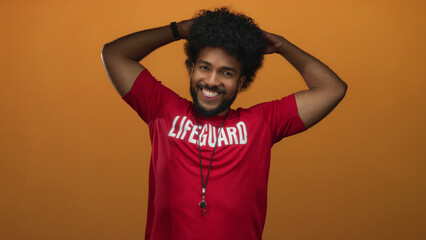 Man smiling lifeguard holding head orange background african american isolated cheerful