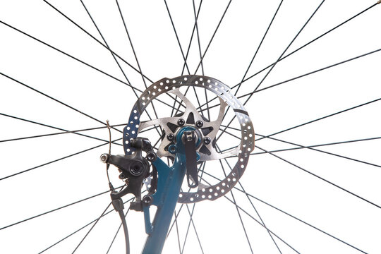 Close-up view of a bicycle wheel with spokes and brake components in bright light
